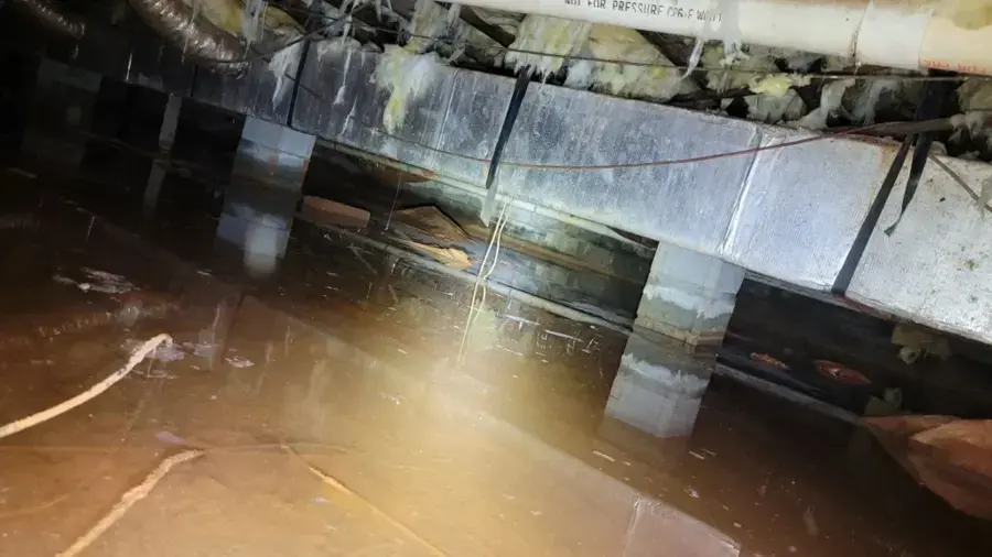 Standing water in a crawl space under a raised wood floor